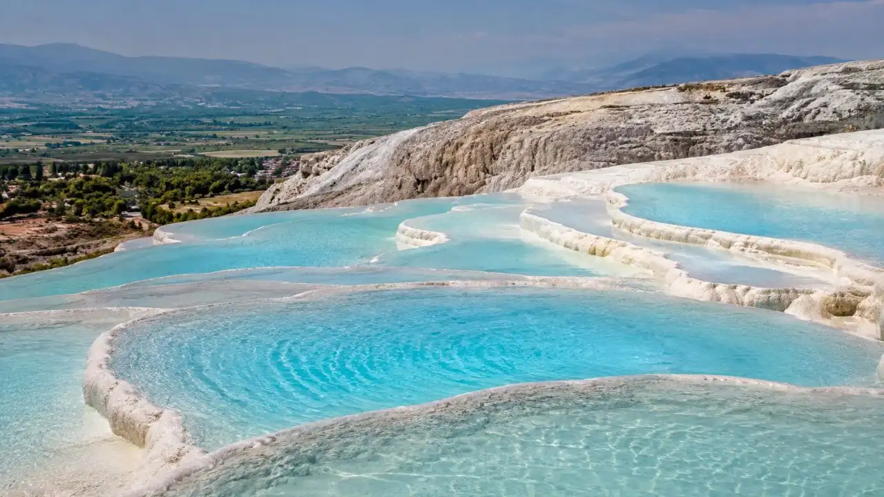 Piscinas brancas e águas azuis em terraços naturais